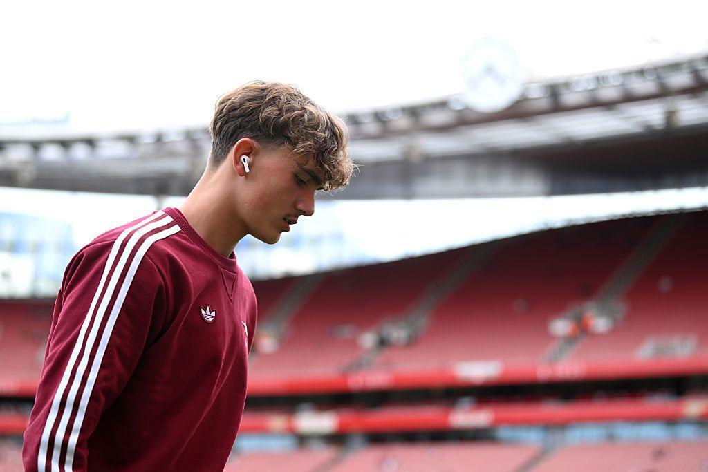 Max Dowman of Arsenal, wearing wireless earbuds inspects the pitch prior to a game.