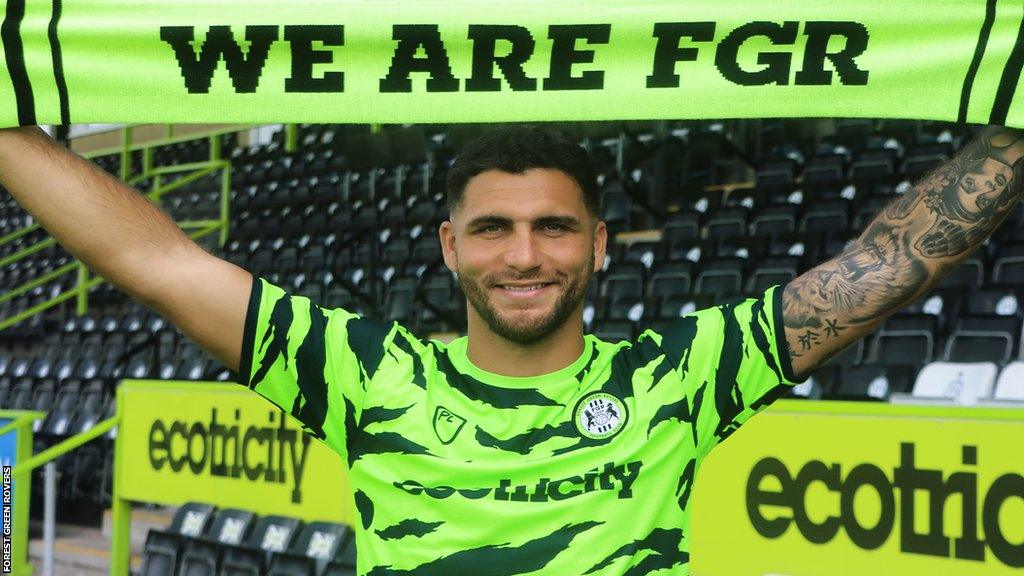 Ryan Inniss holds up a scarf after joining Forest Green Rovers