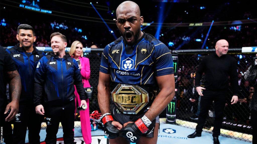 Jon Jones celebrates with his belt around his waist