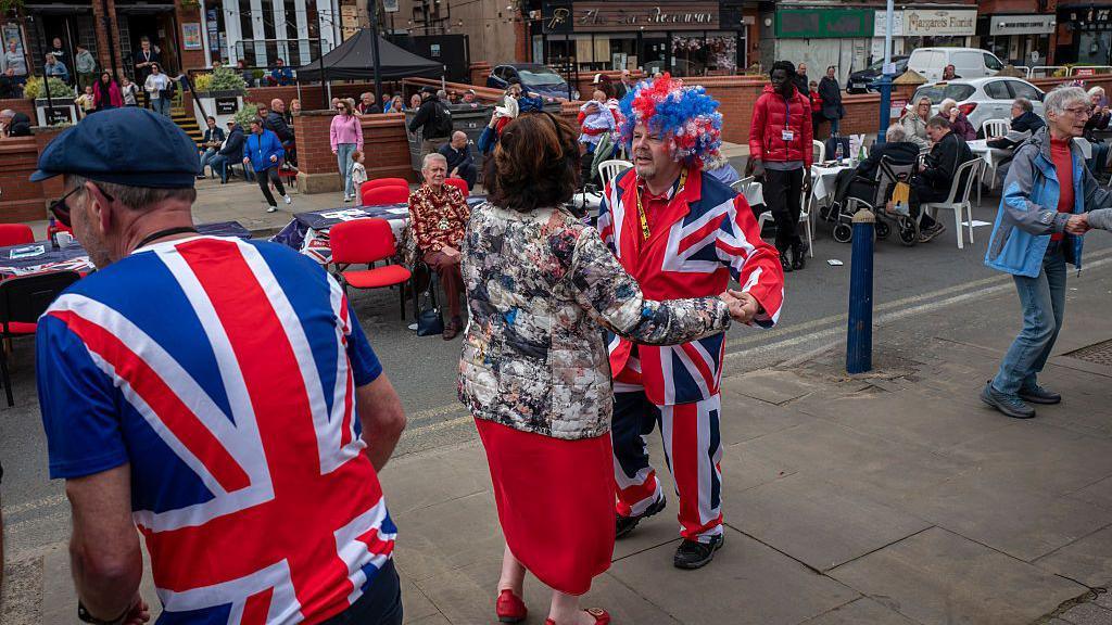 Members of the public dance during in a VE Day street party