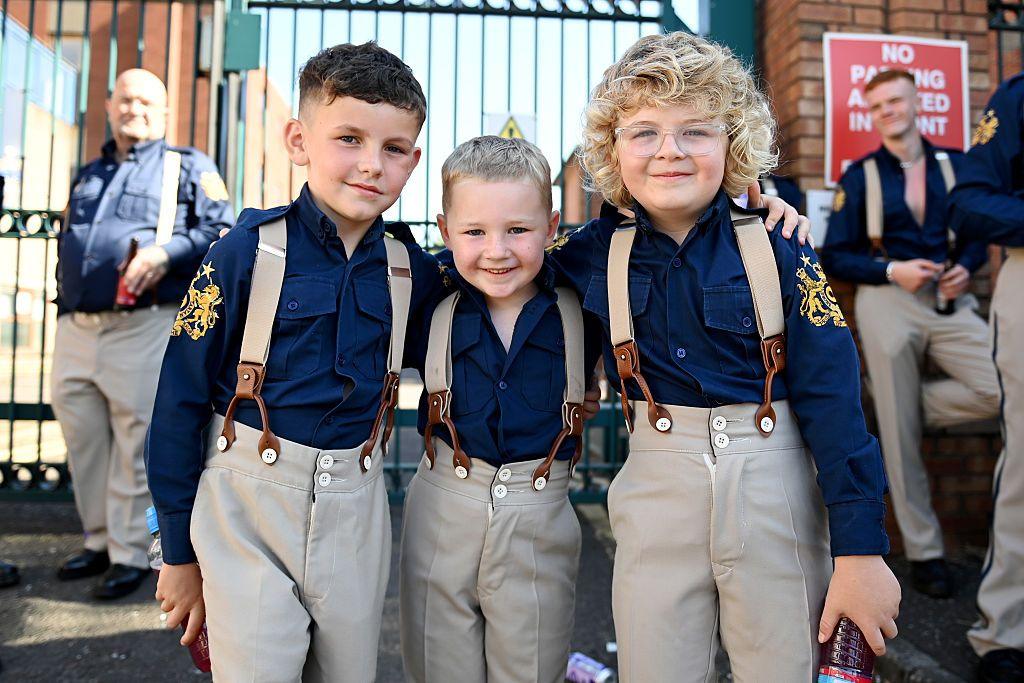 oung members of a flute band take part in the annual Twelfth of July parade. They are wearing dark blue shirts with khaki trousers and braces.