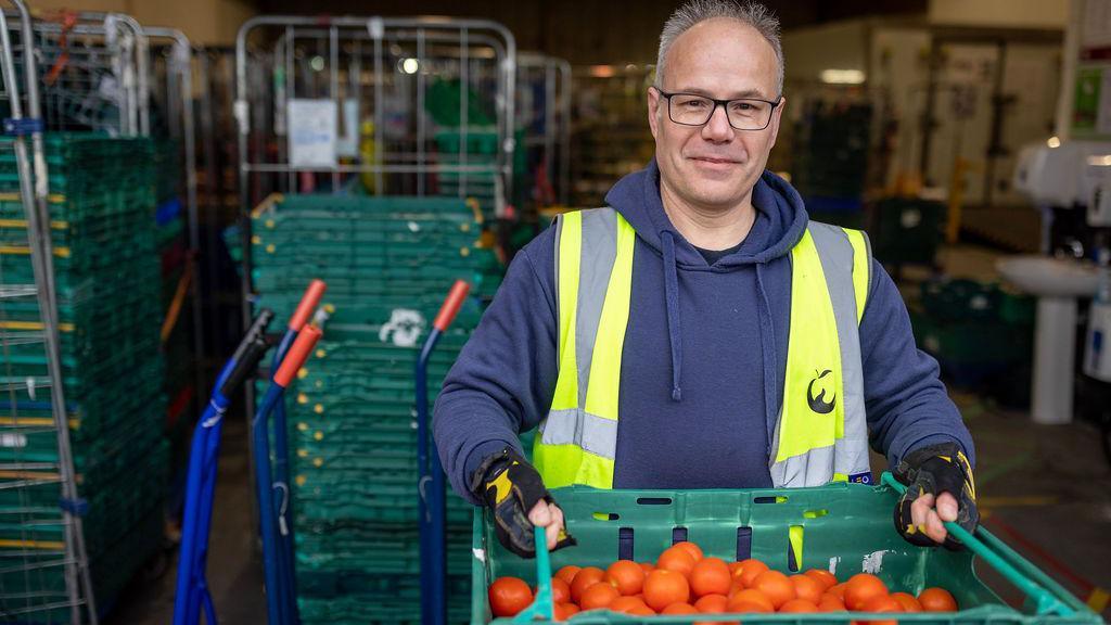 man holding oranges