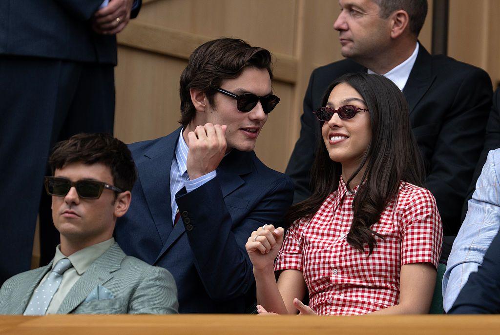 Olivia Rodrigo watches on from the Wimbledon Centre Court royal box while sat alongside Louis Partridge and behind Tom Daley