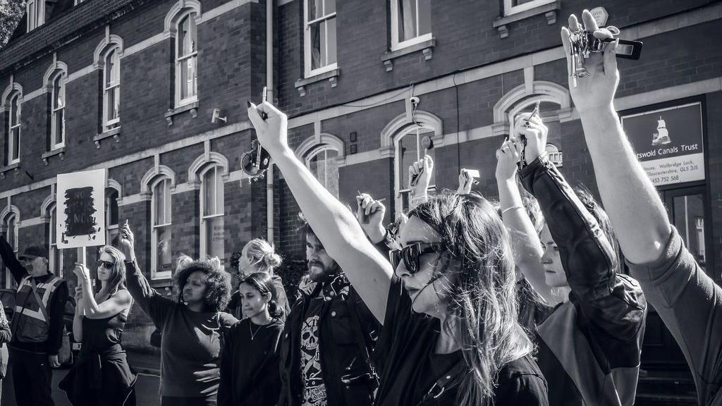 A black and white image of a group of women protesting, holding up car keys to show how they defend themselves.