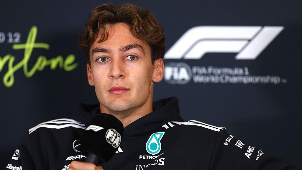 George Russell holds a microphone during the Silverstone news conference 