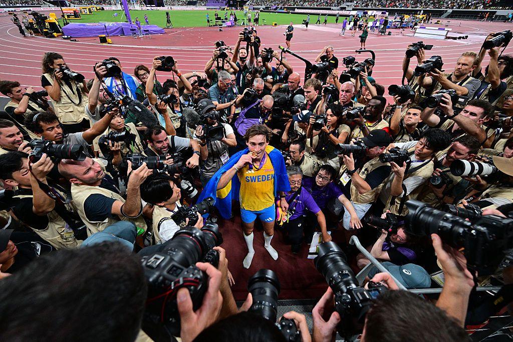 Armand Duplantis surrounded by photographers as he poses with his world gold medal