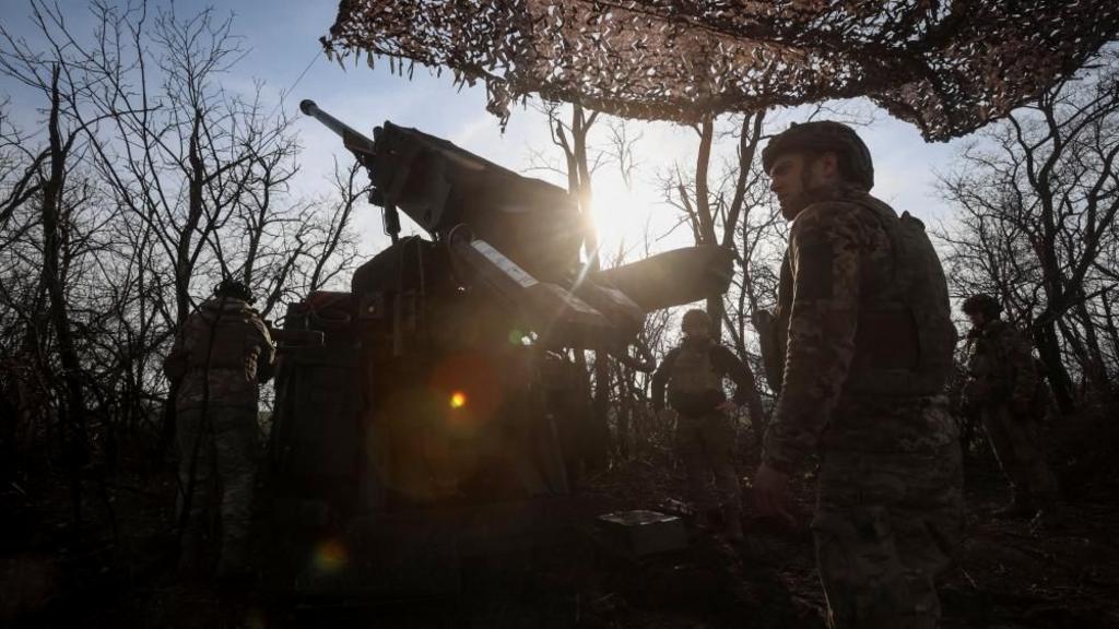 Soldiers prepare a self-propelled howitzer