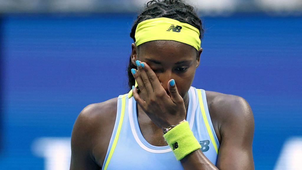 USA's Coco Gauff wipes her face after losing her women's singles round of 16 tennis match against USA's Emma Navarro 