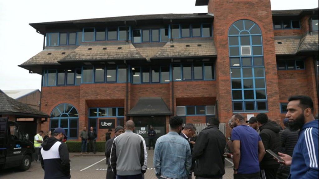 Drivers standing outside an Uber building