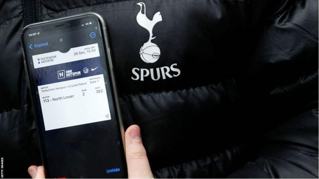 A Tottenham fan shows their digital ticket on their mobile phone