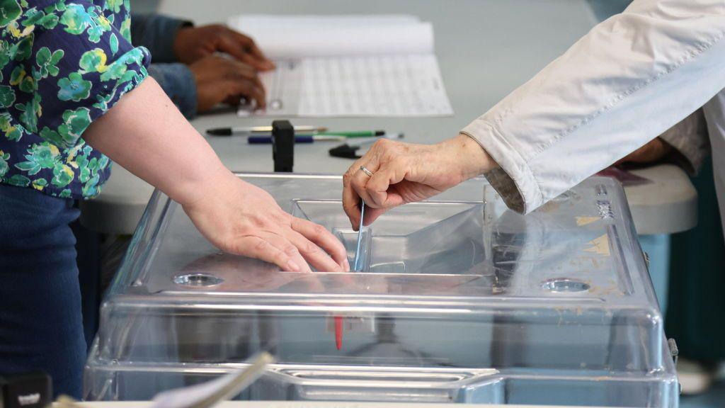 A voter casts a ballot in the 15th district of Paris as France goes to the polls to vote in the of legislative elections.