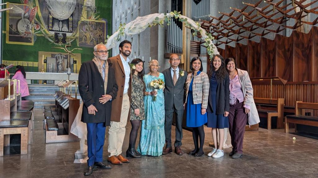 A family standing in a church wearing wedding attire