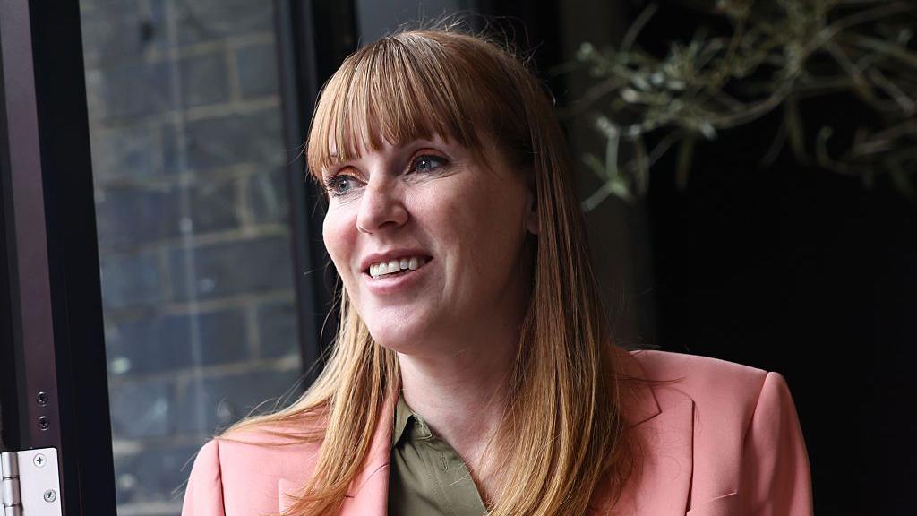 Angela Rayner wearing green shirt and salmon coloured suit.