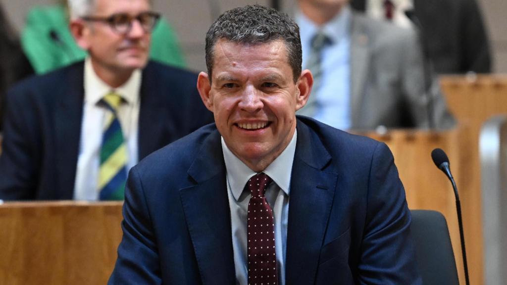 Rhun ap Iorwerth smiling as he sits within the Senedd chamber