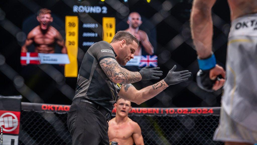 Referee Mark Goddard signals the start of the second round between Jack Cartwright and Jonas Magard at Oktagon 52 in Newcastle