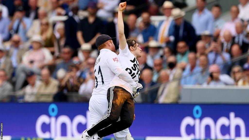 England wicketkeeper Jonny Bairstow carries off a protester