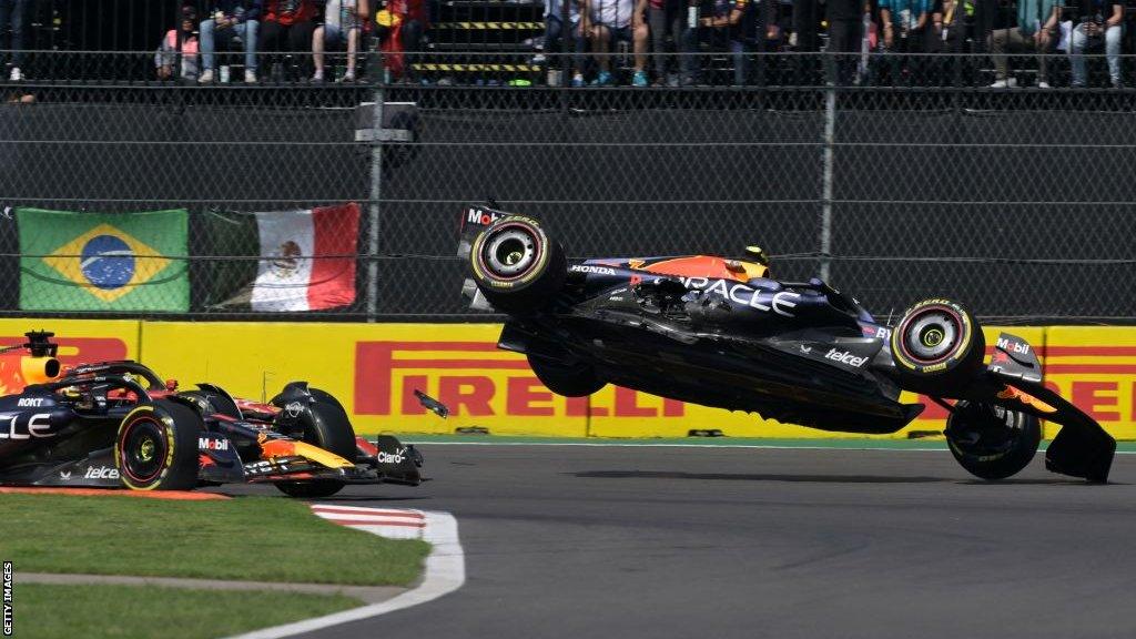 sergio perez's Red Bull flies through the air after colliding with Charles Leclerc's Ferrari on lap 1 of the Mexico City Grand Prix