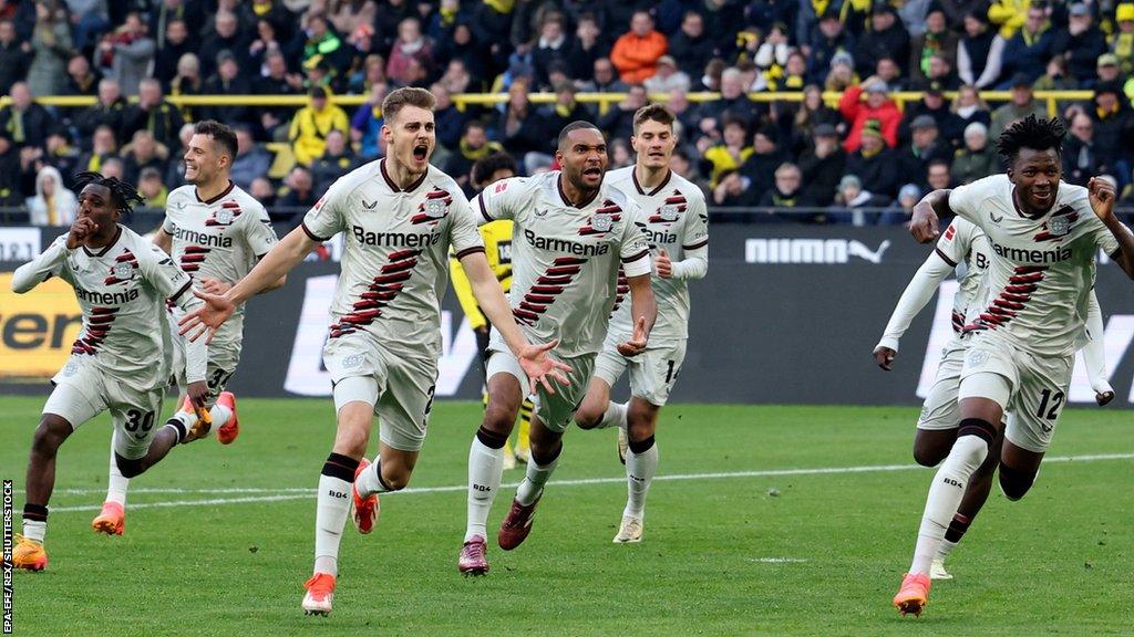 Bayer Leverkusen players celebrate Josip Stanisic's goal against Borussia Dortmund