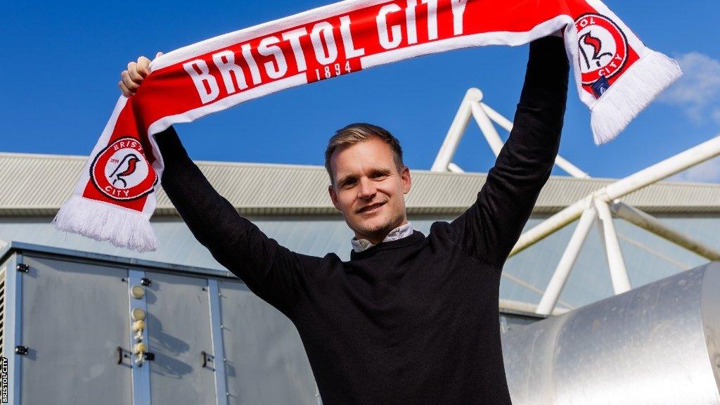 Liam Manning holds aloft a Bristol City scarf