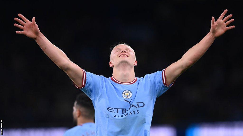 Erling Haaland with his arms outstretched in the air