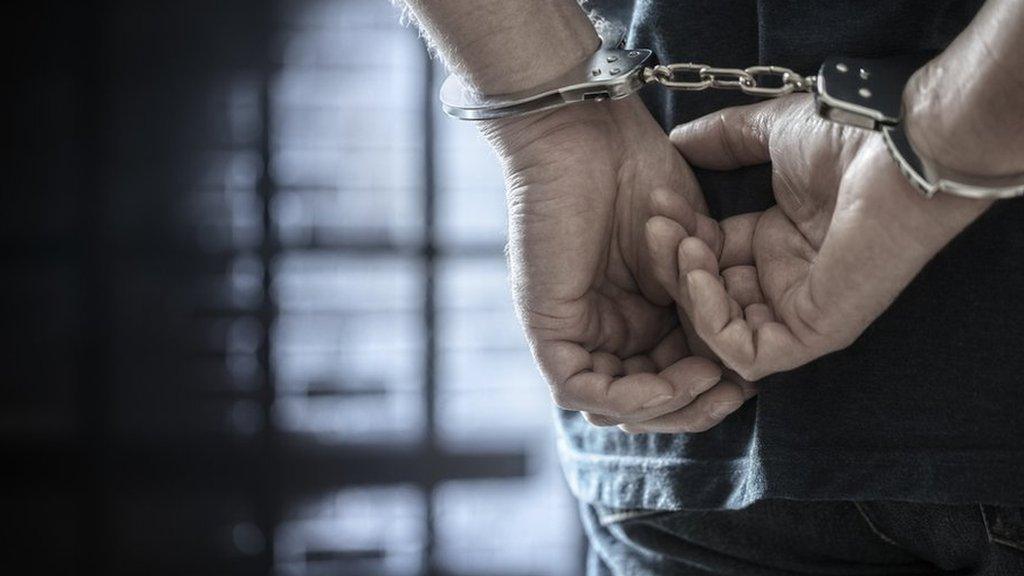 A man's hands in handcuffs