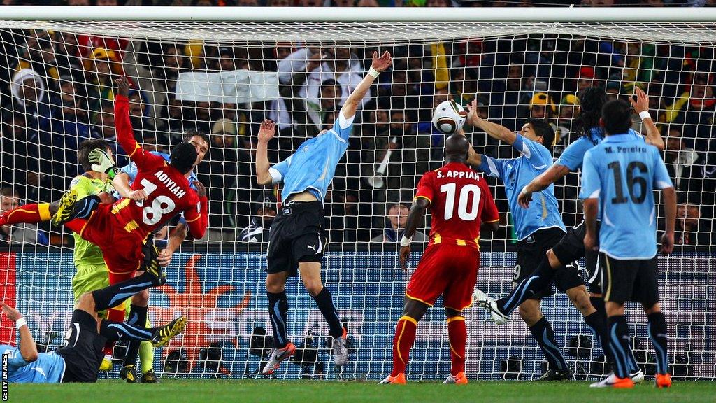 Luis Suarez keeps out a header from Dominic Adiyiah during the Uruguay vs Ghana World Cup quarter-final tie at Soccer City in Johannesburg