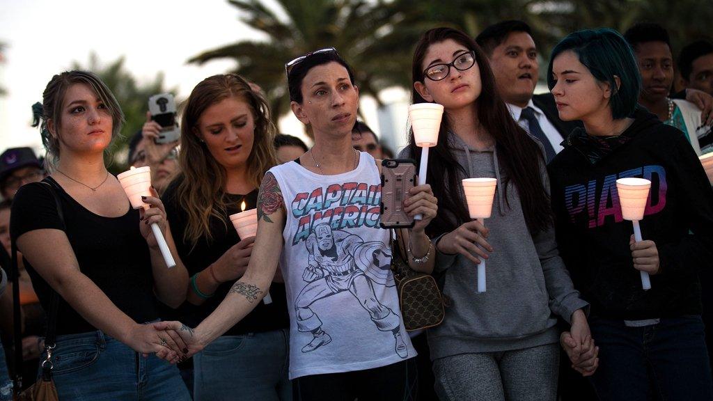 Mourners attend a candlelight vigil at the corner of Sahara Avenue and Las Vegas Boulevard for the victims of Sunday night's mass shooting (2 October)