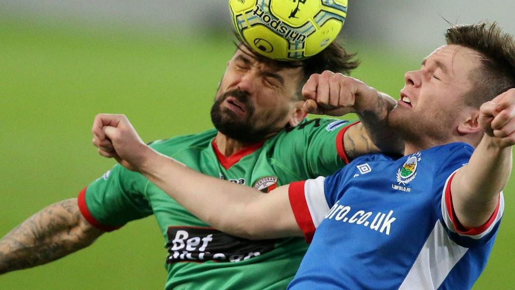 Glentoran striker Nacho Novo beats Linfield's Niall Quinn to the high ball