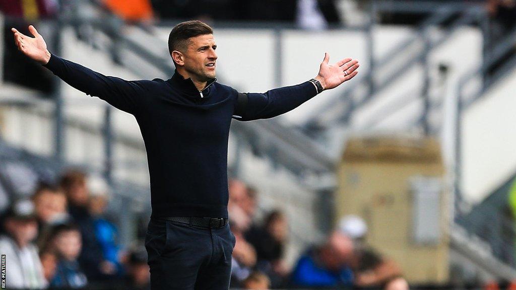 Portsmouth boss John Mousinho disagrees with the referee during a League One match.