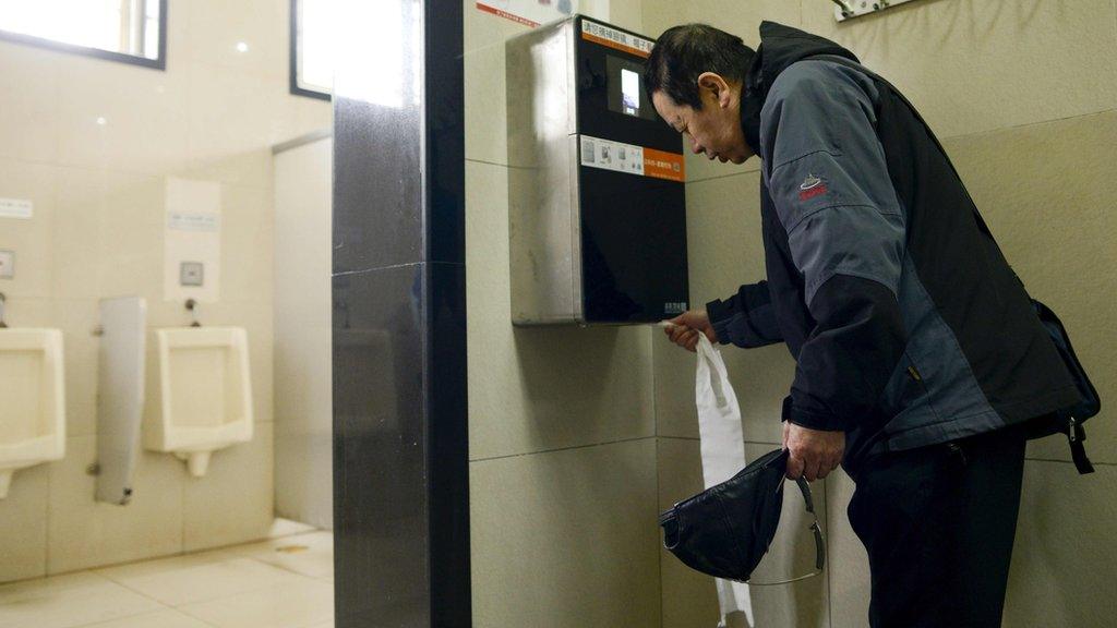 man uses loo role dispenser