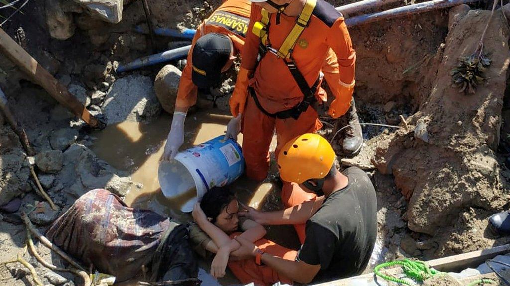 Rescuers try to pull out a woman trapped in the rubble in Palu. Photo: 30 September 2018