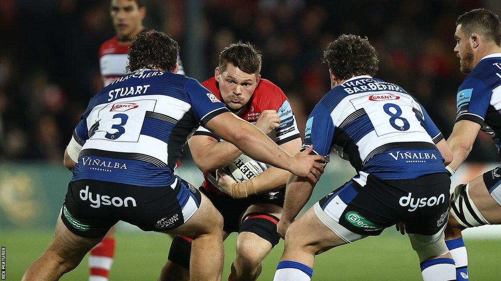 Freddie Clarke braces with the ball for a tackle by two Bath players