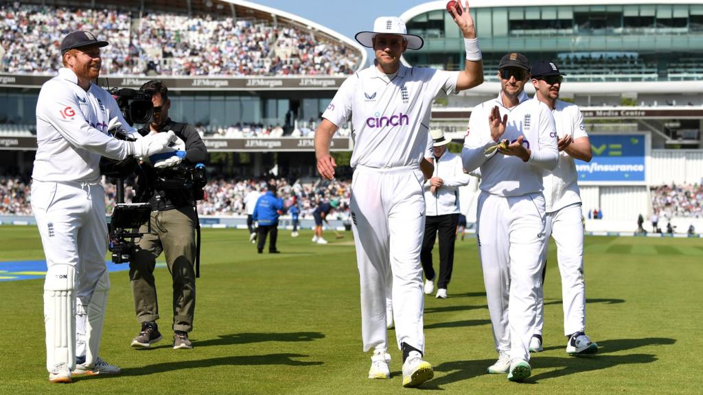 Stuart Broad walks off holding the ball aloft after taking five wickets against Ireland