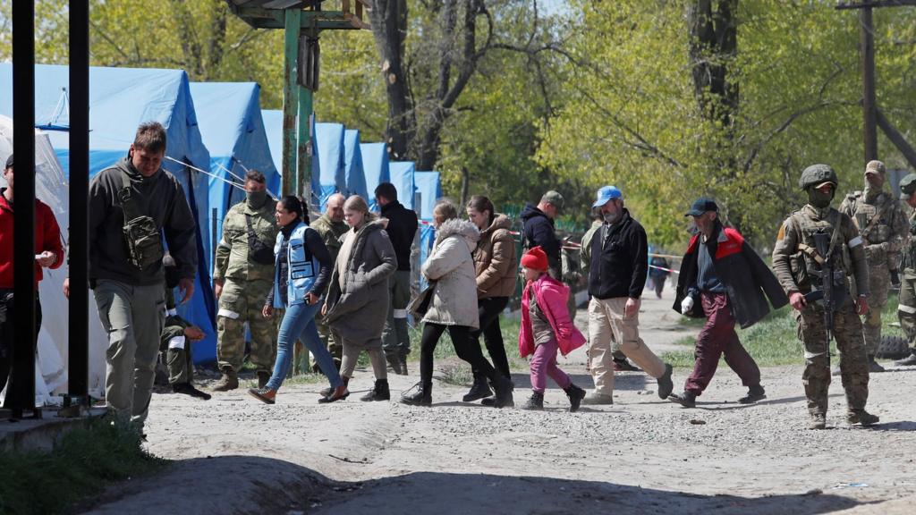 Civilians who left the area near Azovstal steel plant in Mariupol walk at a temporary accommodation centre in Bezimenne