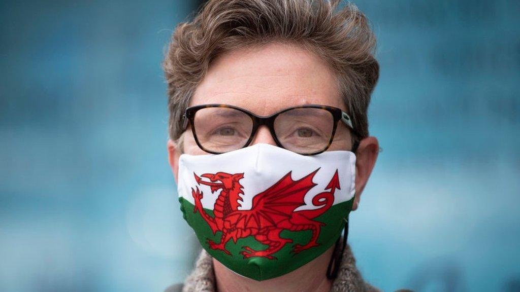 Woman wearing mask with Welsh flag on