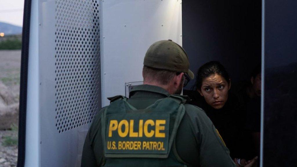 A US immigration official detains a migrant