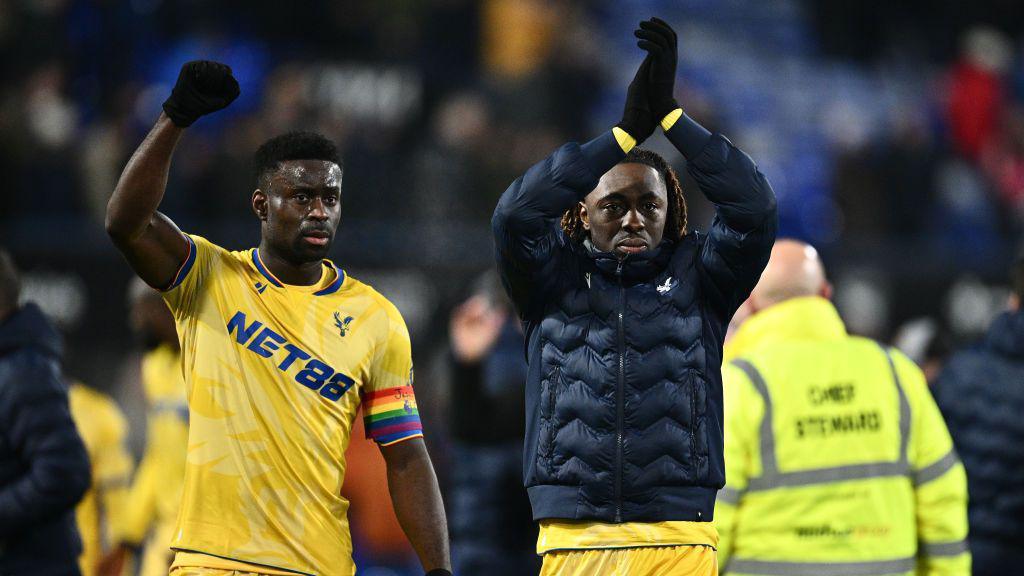 Marc Guehi and Eberechi Eze celebrate and applaud the Palace fans
