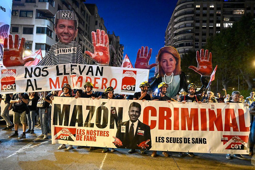 Demonstrators hold up banners depicting the regional President Carlos Mazon and vice-president Susana Camarero