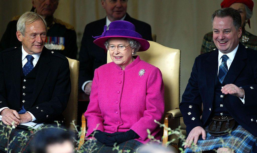 Reid with the Queen and Jack McConnell in 2004. They are sitting in a row, laughing.