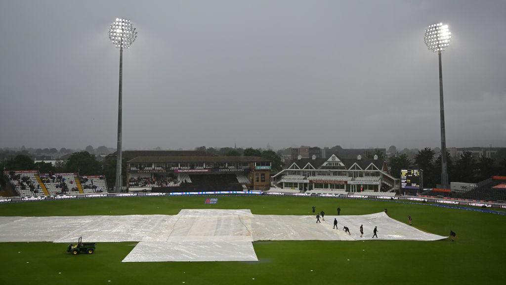 The County Ground at Taunton in heavy rain with the covers being brought on