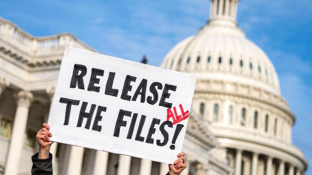 A demonstrator holds a poster during a press conference with survivors of convicted sex offender Jeffrey Epstein on the Epstein Files Transparency Act outside the U.S. Capitol in Washington, DC on Tuesday, November 18, 2025. The House is expected to vote later today on the legislation which would force the U.S. Department of Justice to release all files related to the late accused sex trafficker Jeffrey Epstein.