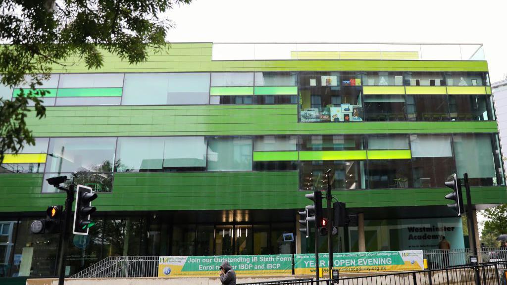 The outside of Westminster Academy, a modern green building with large windows 