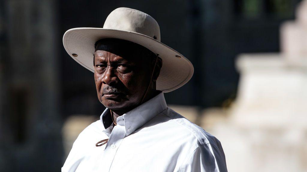 Uganda's President Yoweri Museveni wears a white shirt and a matching wide-brimmed hat. 