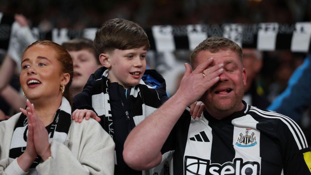 A Newcastle fan wipes his eye after seeing his side win the Carabao Cup