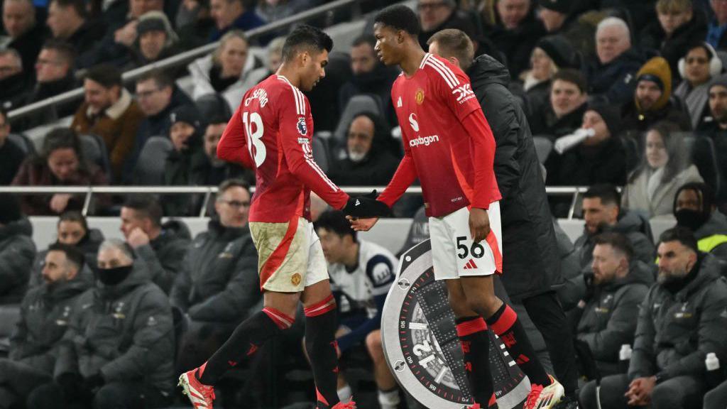 Number 56 Chido Obi, right, comes on to replace Manchester United's number 18 Casemiro, left.