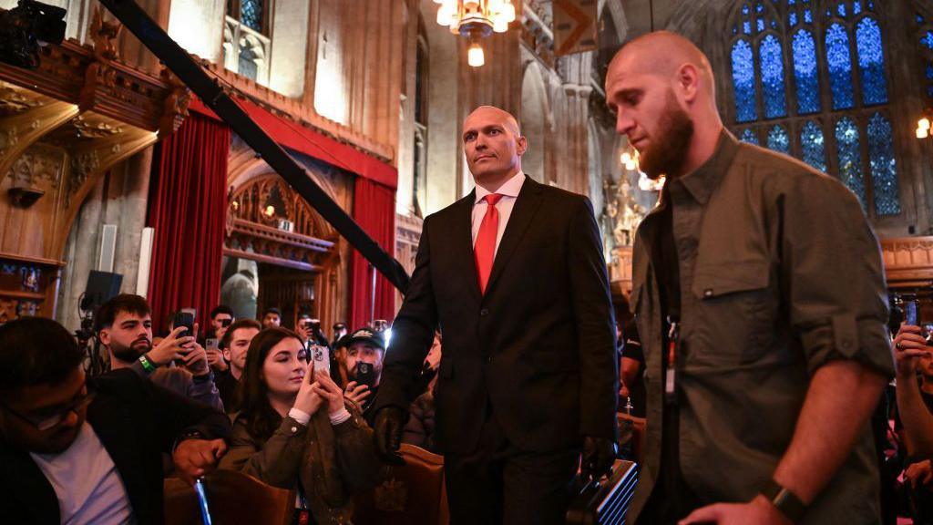 Oleksandr Usyk dressed as Agent 47 in a black suit and tie