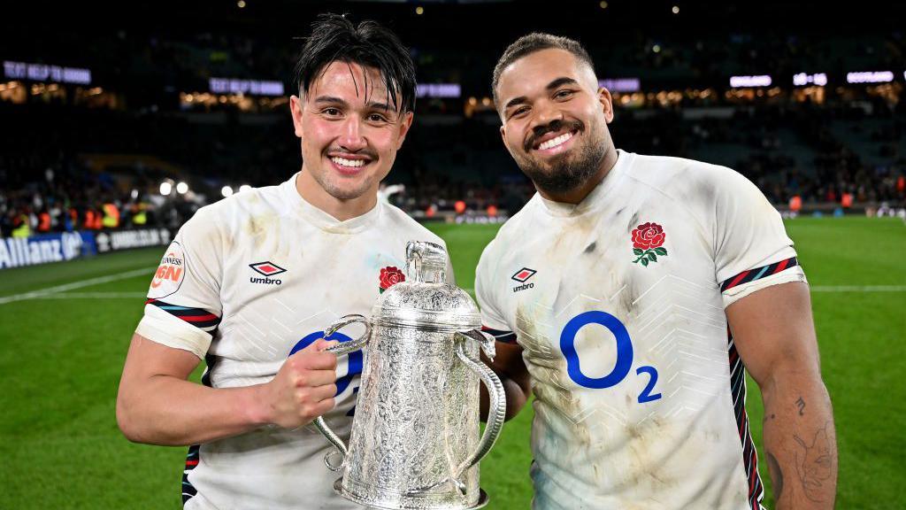 Marcus Smith and Ollie Lawrence holding the Calcutta Cup