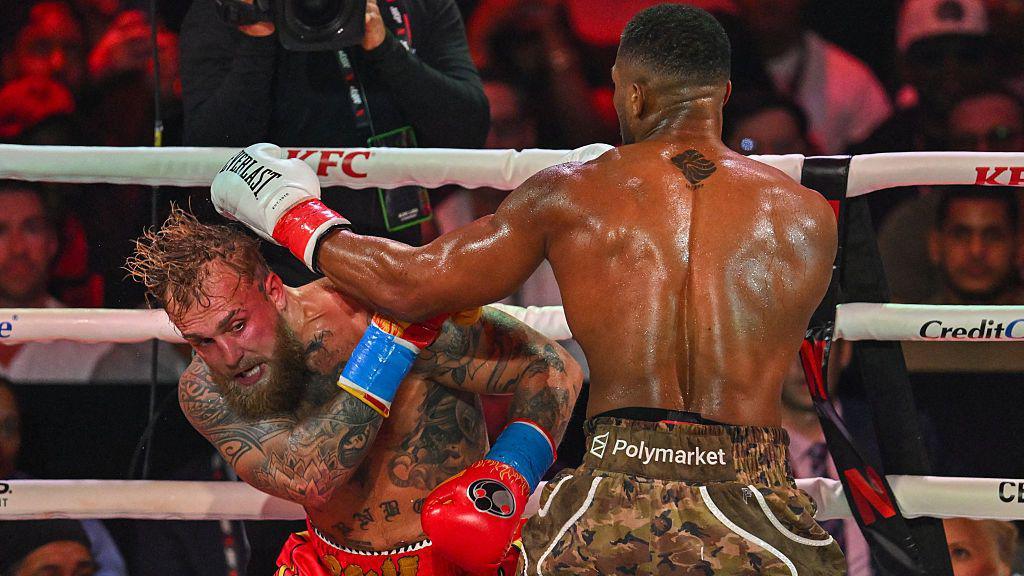 US boxer and influencer Jake Paul (L) and British boxer Anthony Joshua fight