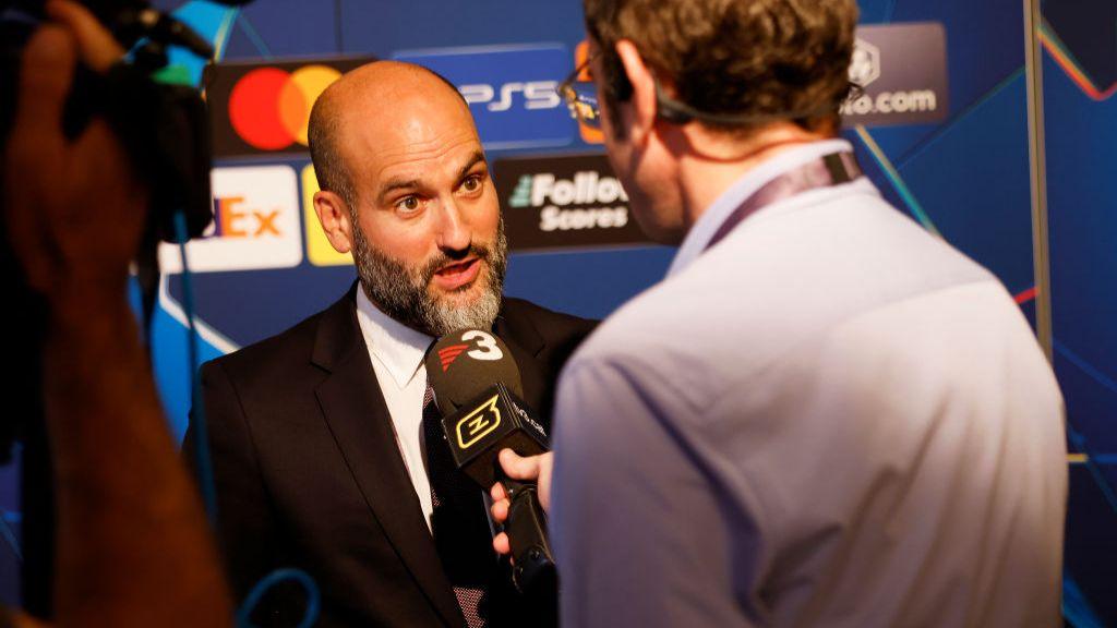 Girona chairman Pere Guardiola speaks to a journalist.