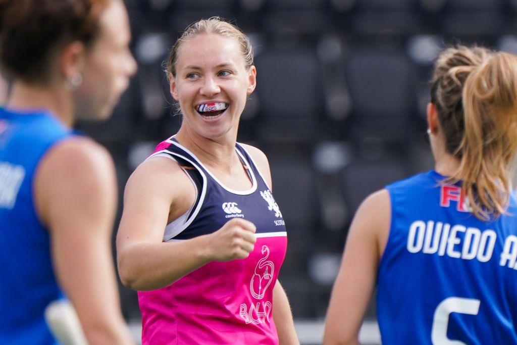 Hockey player Sarah Robertson wears big smile and punches the air after scoring in a hockey game.